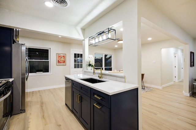 kitchen featuring light wood-type flooring, appliances with stainless steel finishes, visible vents, and a sink