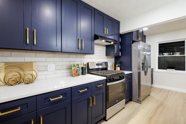 kitchen featuring appliances with stainless steel finishes, light countertops, blue cabinets, and under cabinet range hood