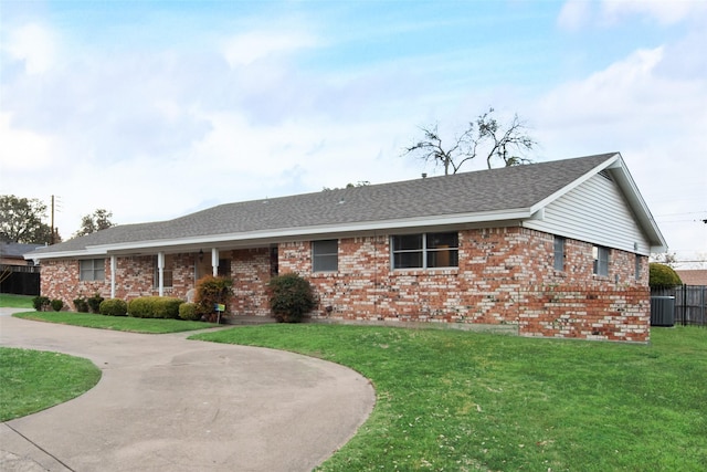 ranch-style home featuring a front yard, brick siding, fence, and central air condition unit