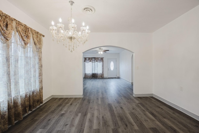 unfurnished dining area featuring dark wood-style floors, baseboards, visible vents, and arched walkways