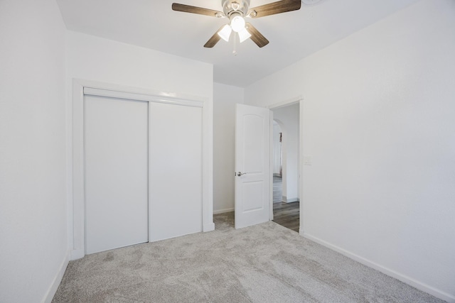 unfurnished bedroom with carpet floors, a closet, ceiling fan, and baseboards