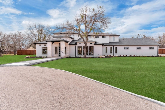 view of front of home with a front yard and fence