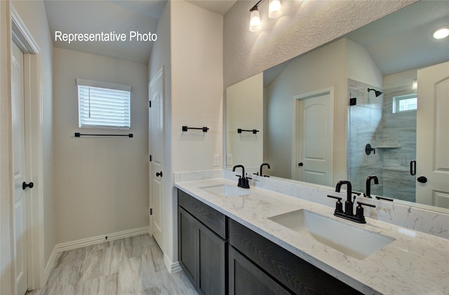 full bath with a wealth of natural light, a sink, and a shower stall