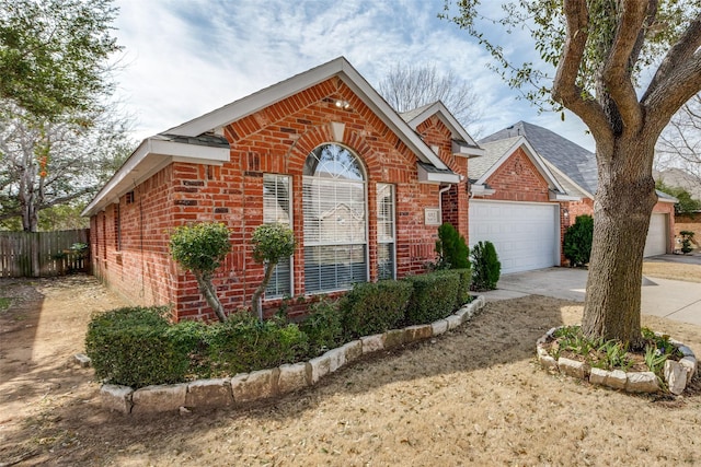 ranch-style home with a garage, driveway, brick siding, and fence