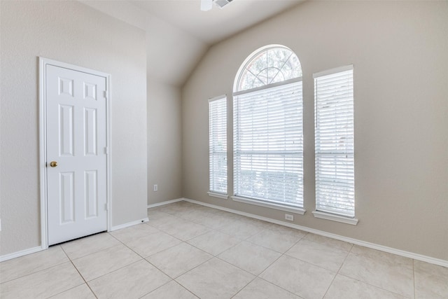 unfurnished room featuring light tile patterned floors, baseboards, and vaulted ceiling