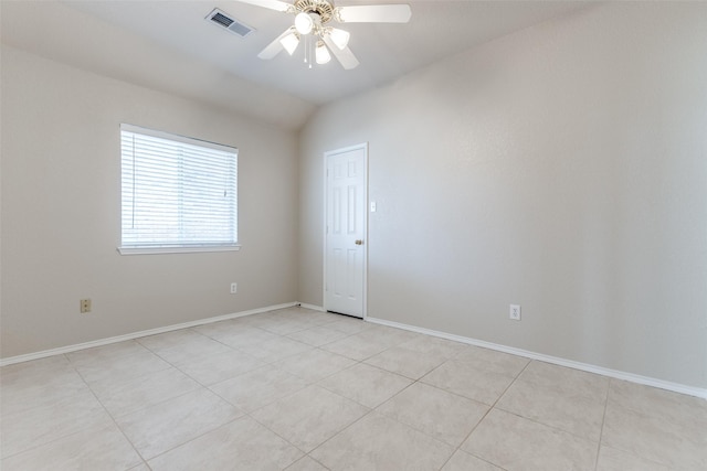 empty room featuring light tile patterned floors, lofted ceiling, visible vents, ceiling fan, and baseboards