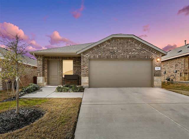 view of front of property featuring driveway, brick siding, an attached garage, and a shingled roof