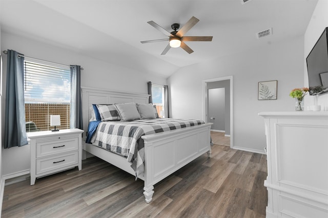 bedroom with wood finished floors, a ceiling fan, visible vents, vaulted ceiling, and baseboards