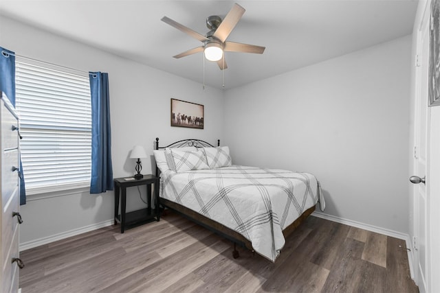 bedroom with wood finished floors, a ceiling fan, and baseboards