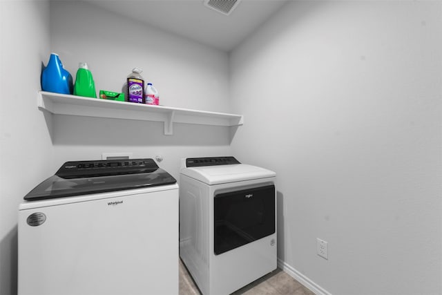 washroom with light tile patterned floors, washing machine and dryer, laundry area, visible vents, and baseboards