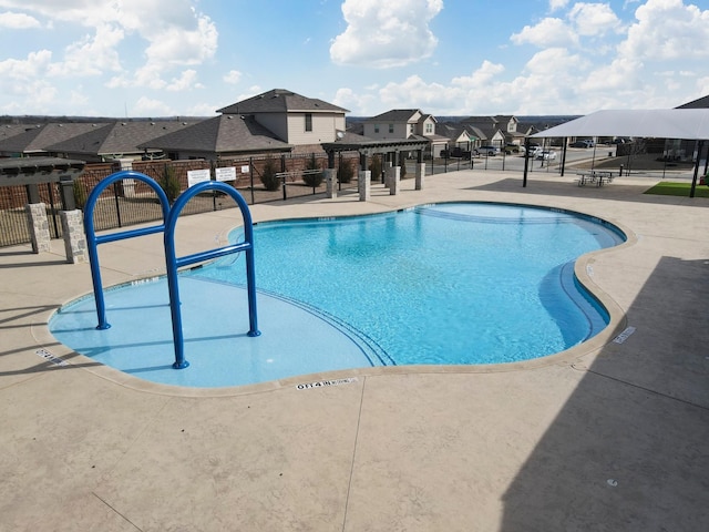 community pool with a residential view, a patio area, fence, and a pergola