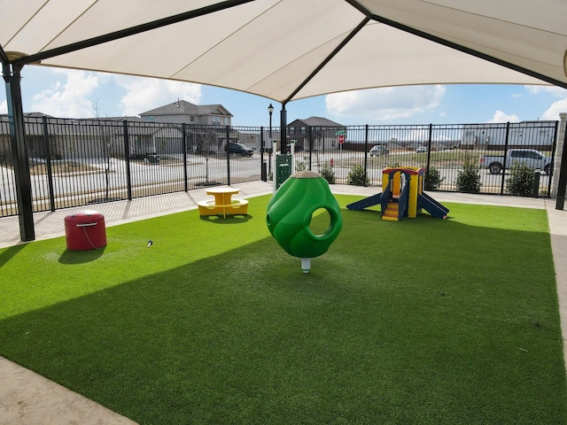 view of jungle gym with a yard and fence