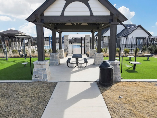 view of home's community with fence, a gazebo, and a lawn