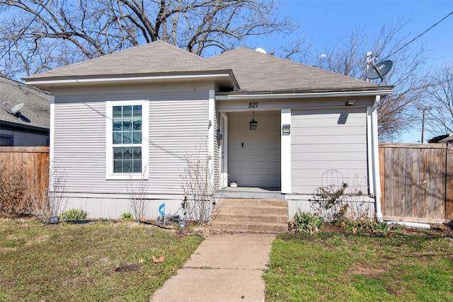 view of front of house featuring a porch, a front yard, fence, and a shingled roof