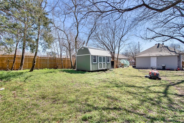 view of yard featuring an outbuilding, a storage unit, and fence