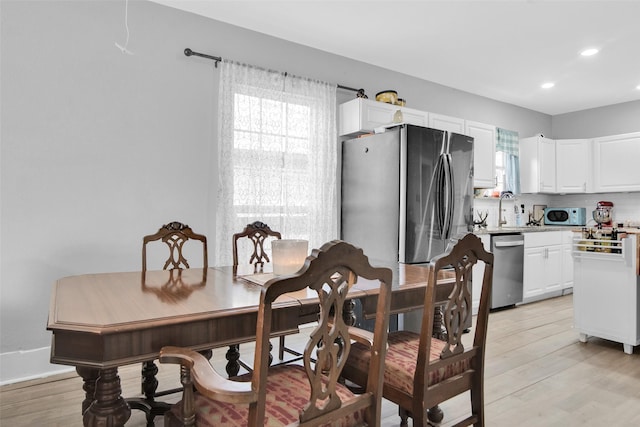 dining room with light wood-type flooring and recessed lighting