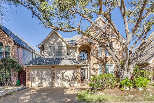 view of front of home featuring a garage, brick siding, driveway, and a shingled roof