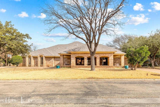 french country style house with brick siding and roof with shingles