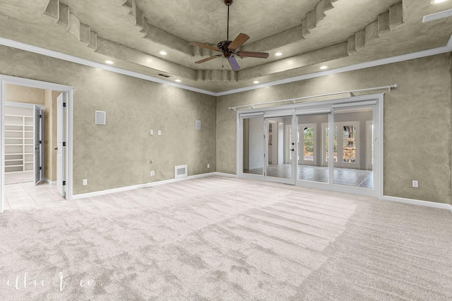 carpeted empty room featuring recessed lighting, visible vents, baseboards, a ceiling fan, and a raised ceiling