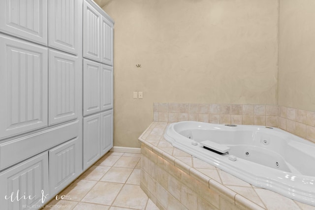 full bath with a whirlpool tub, baseboards, and tile patterned floors