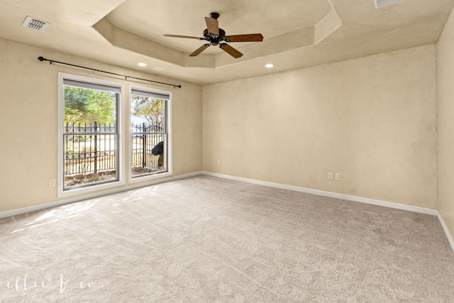 carpeted empty room with a ceiling fan, recessed lighting, a raised ceiling, and baseboards