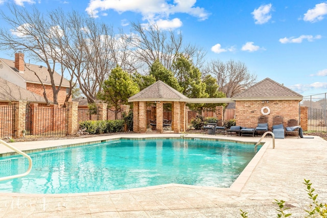 view of pool with a fenced in pool, fence, an exterior structure, a patio area, and an outdoor structure