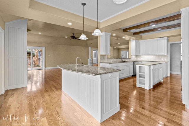 kitchen featuring an island with sink, light wood-type flooring, and white cabinetry