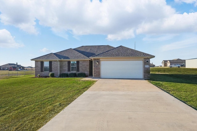 ranch-style home featuring a front yard, concrete driveway, brick siding, and a garage