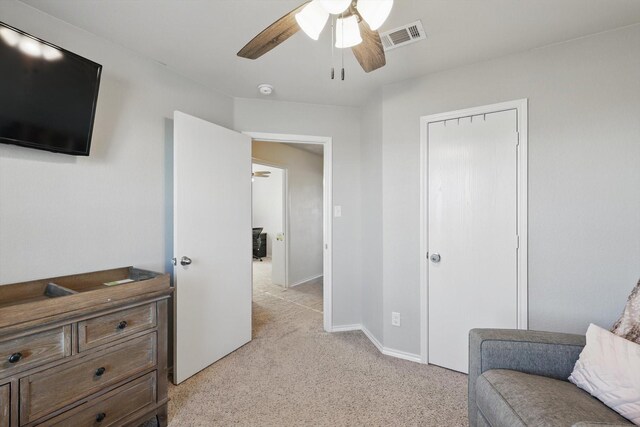 sitting room featuring visible vents, light colored carpet, baseboards, and a ceiling fan