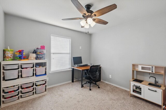 carpeted home office with baseboards and ceiling fan