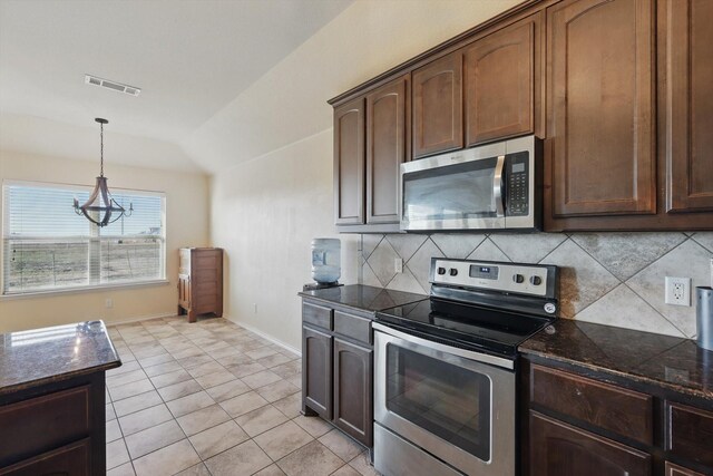 kitchen featuring decorative light fixtures, decorative backsplash, stainless steel appliances, and lofted ceiling