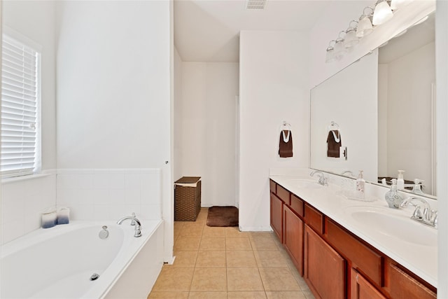 bathroom with a bath, tile patterned flooring, double vanity, and a sink