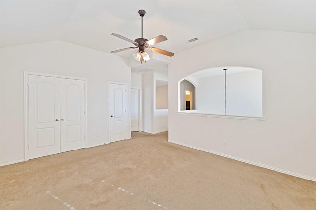 unfurnished bedroom with vaulted ceiling, carpet, visible vents, and baseboards