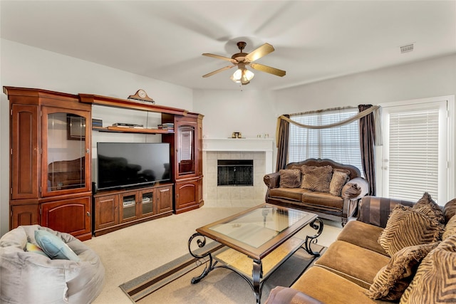 living area featuring visible vents, carpet floors, a fireplace, and a ceiling fan