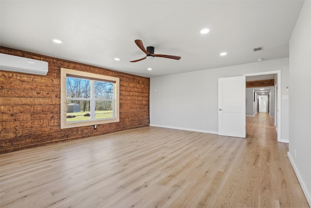 230 Frosty Hollow Rd, Denison, TX 75021 - unfurnished room with a wall mounted AC, a ceiling fan, light wood-type flooring, wood walls, and recessed lighting