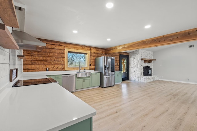 230 Frosty Hollow Rd, Denison, TX 75021 - kitchen featuring green cabinetry, stainless steel appliances, wall chimney exhaust hood, a stone fireplace, and a sink