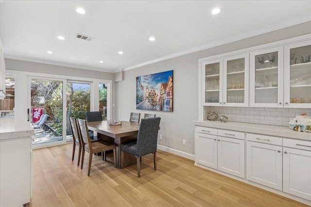 dining area with light wood finished floors, baseboards, visible vents, crown molding, and recessed lighting