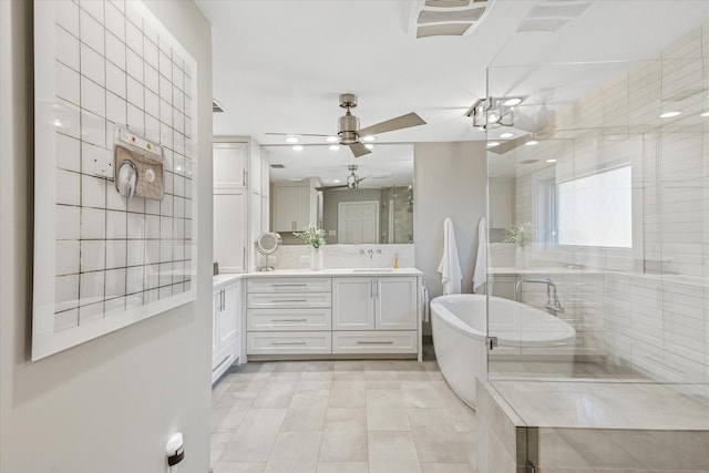 full bath featuring a freestanding tub, recessed lighting, vanity, a ceiling fan, and a shower with door