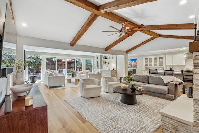 living area featuring high vaulted ceiling, recessed lighting, light wood-style floors, beam ceiling, and a bar