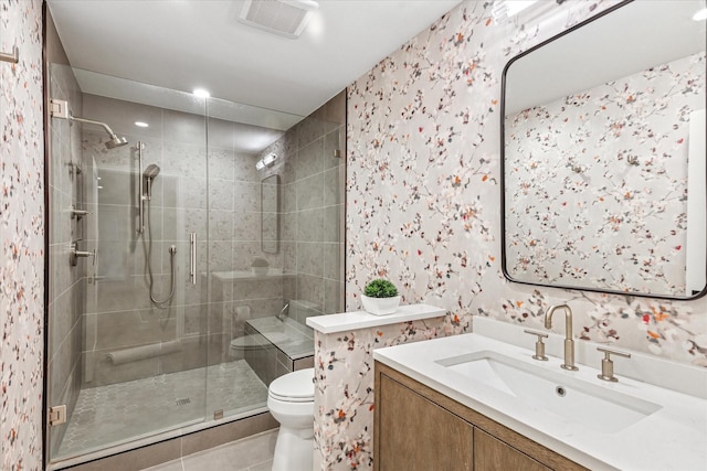 bathroom featuring visible vents, toilet, a shower stall, vanity, and wallpapered walls