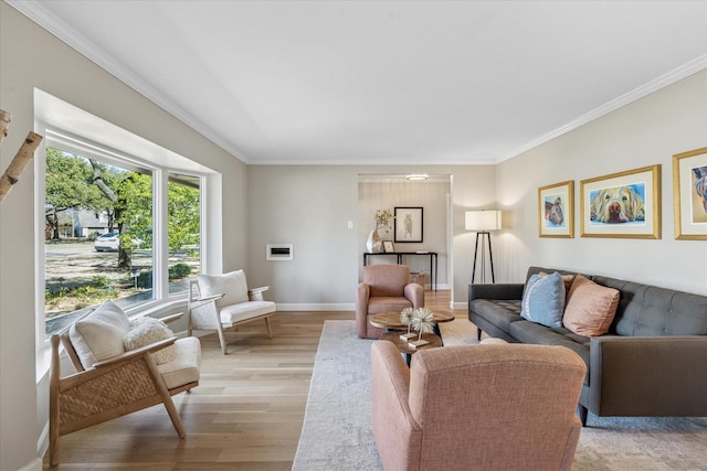 living area featuring light wood-style floors, ornamental molding, and baseboards