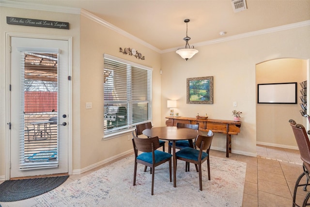 dining space featuring light tile patterned floors, baseboards, visible vents, and ornamental molding