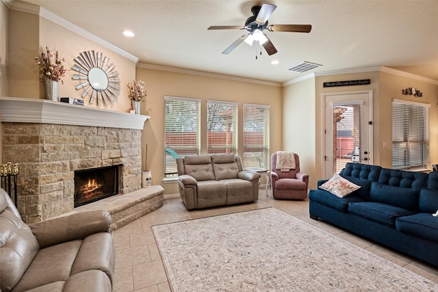 living area with ornamental molding, a fireplace, visible vents, and a ceiling fan