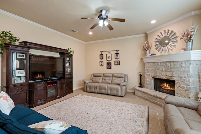 living room with light tile patterned floors, a stone fireplace, ornamental molding, and baseboards