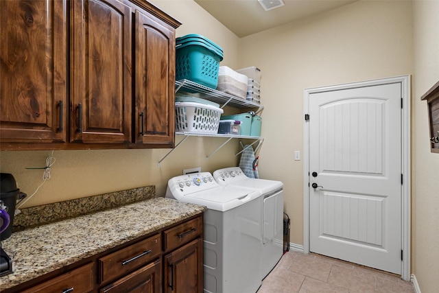 clothes washing area with cabinet space, visible vents, light tile patterned flooring, independent washer and dryer, and baseboards