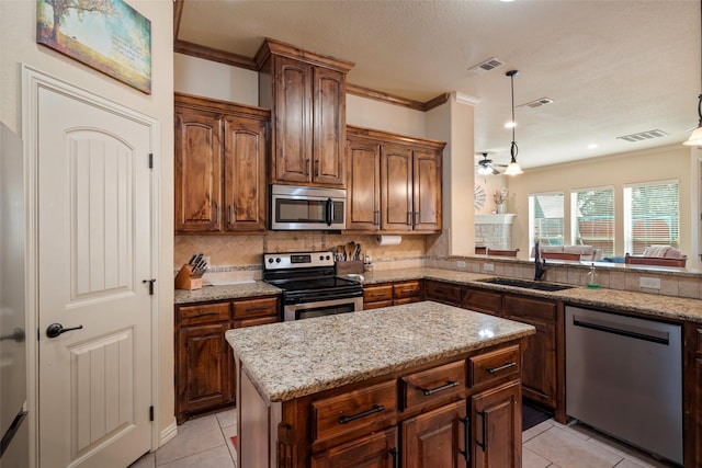 110 Donna Cir, Granbury, TX 76049 - kitchen featuring stainless steel appliances, a sink, crown molding, light tile patterned floors, and decorative backsplash