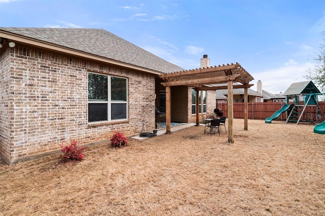 rear view of house featuring a playground, brick siding, a chimney, fence, and a pergola