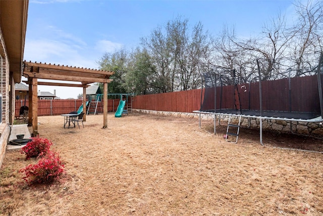 exterior space with a trampoline and a fenced backyard