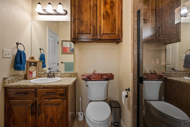 full bathroom with a stall shower, vanity, and toilet