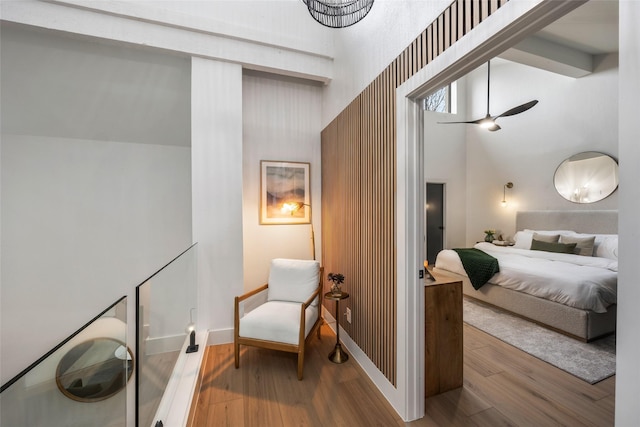 bedroom featuring a high ceiling, baseboards, and wood finished floors